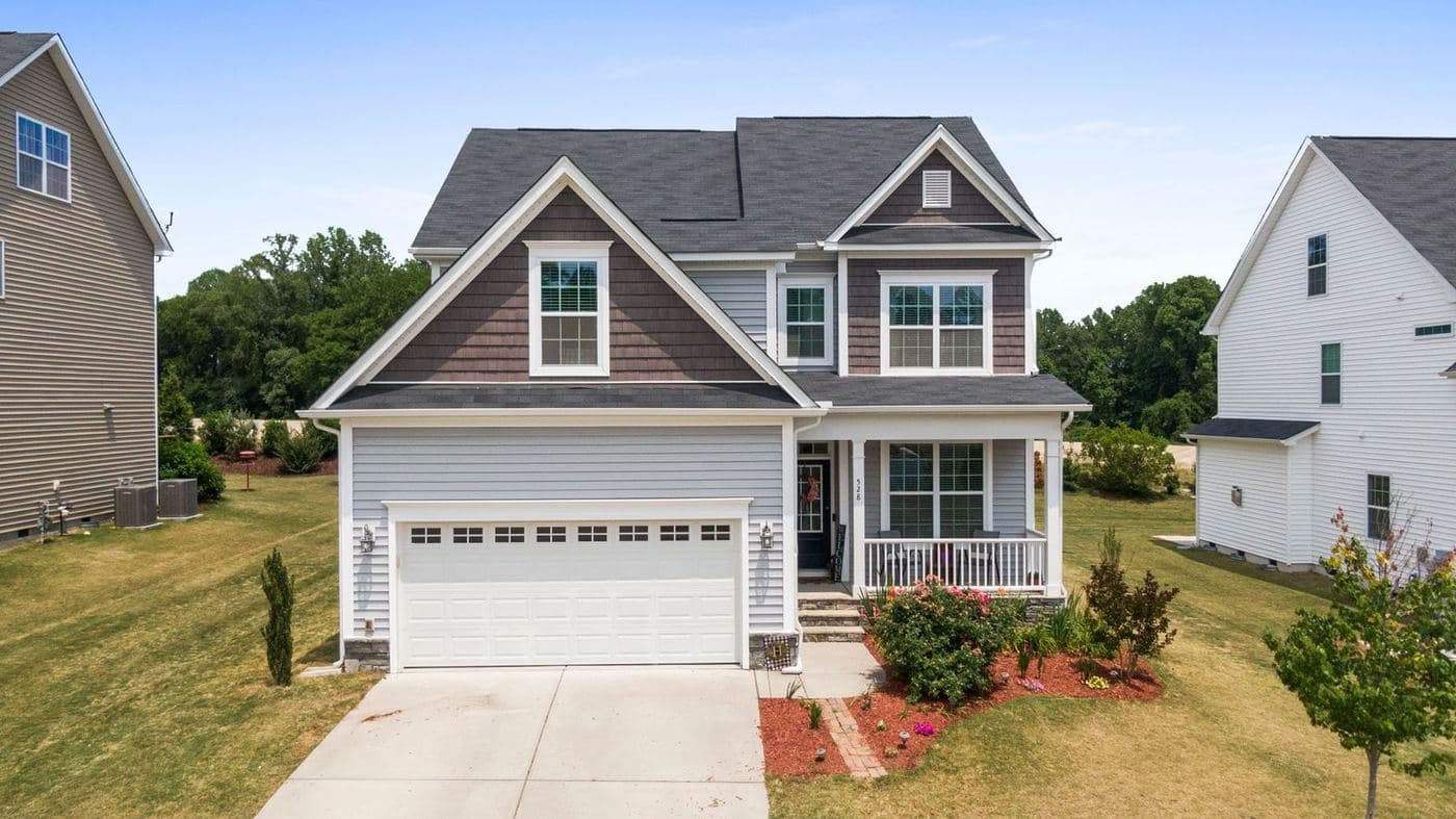 Craftsman-style two-story home with a covered front porch and a two-car garage