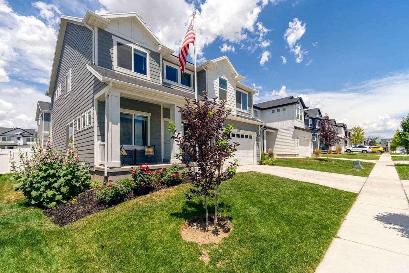 Newer two-story homes with front porches along a neighborhood sidewalk